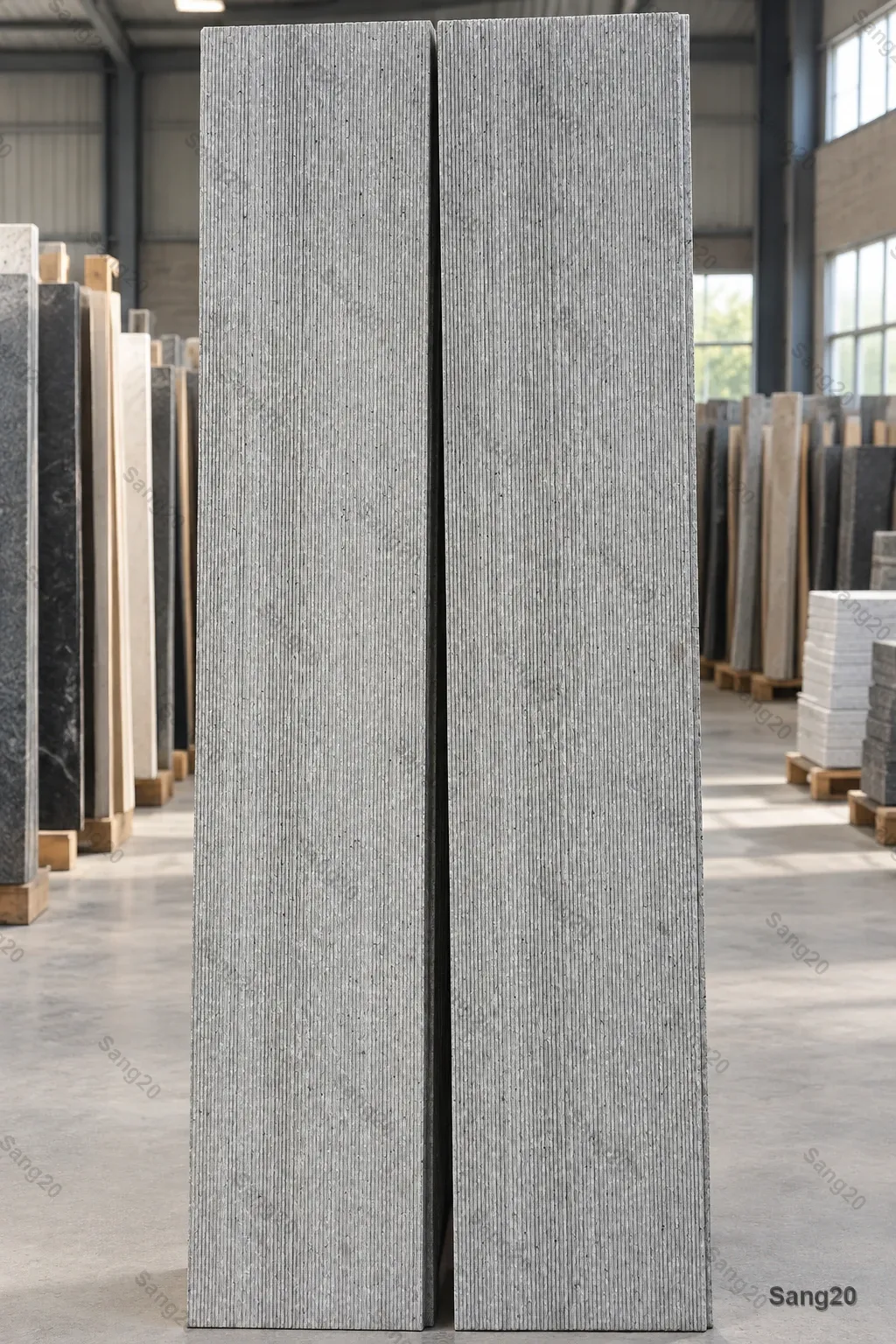 Two gray Hamadan granite panels with a fine texture and regular vertical grooves, displayed in a stone workshop with rows of building stone in the background