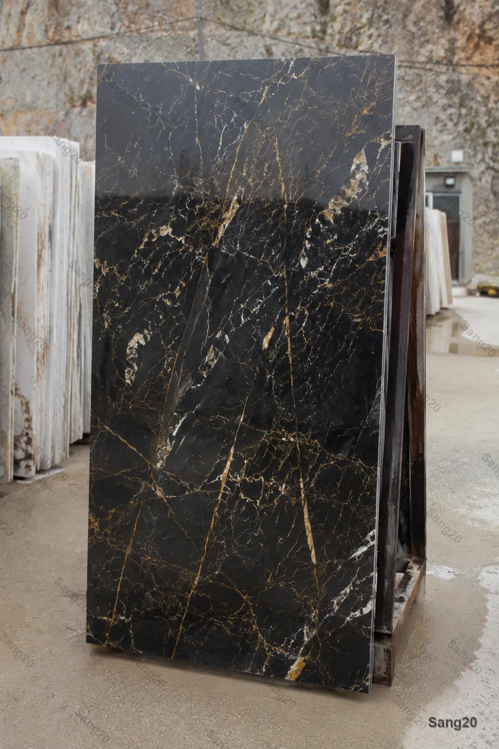 Golden Black marble slab, quarry sample 1, with natural gold veining in a stone yard